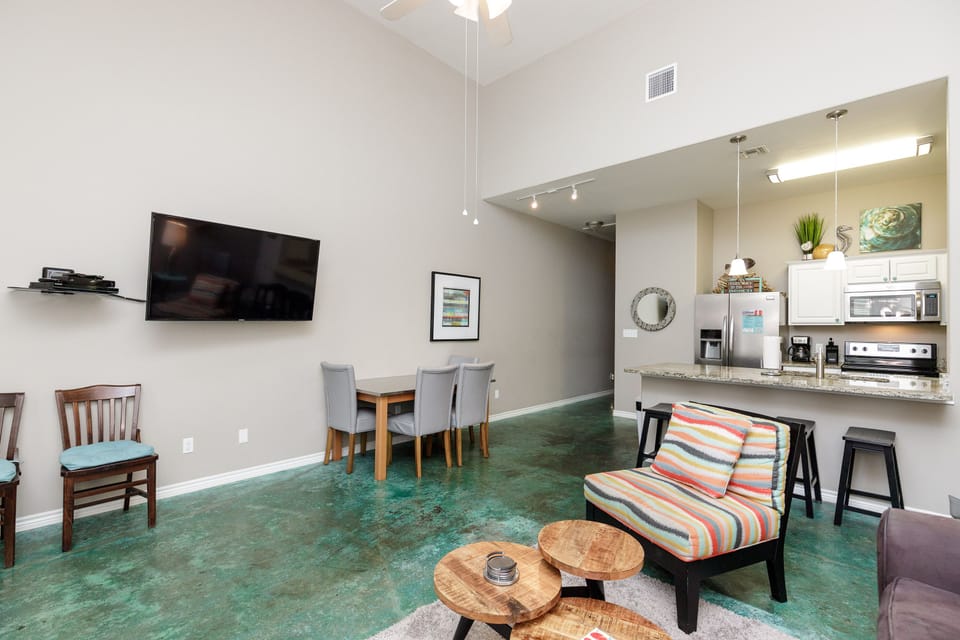 Your spacious open-plan living area flows beautifully from cozy seating to dining table, with a modern kitchen perfect for preparing meals together.
