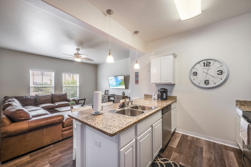 Your open-concept living space seamlessly blends comfort with convenience, featuring a granite kitchen island perfect for morning coffee and cozy leather seating.