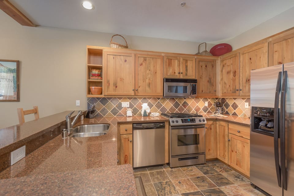 Your fully equipped kitchen features granite countertops, stainless steel appliances, and warm wood cabinets for memorable meal preparation.