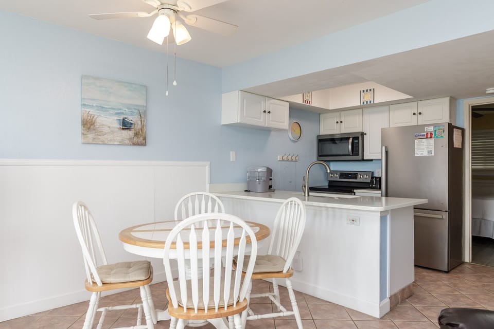 Your bright, coastal-themed kitchen invites you to start each day with coffee and ocean views from your dining table.