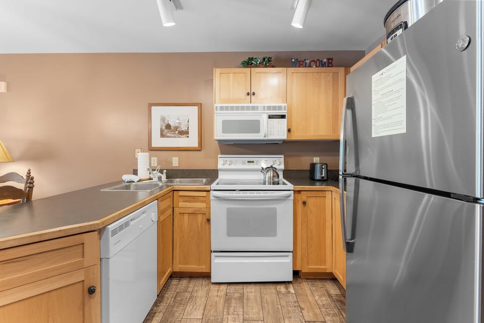Your fully-equipped kitchen features modern appliances and warm wood cabinets, perfect for preparing meals during your stay.