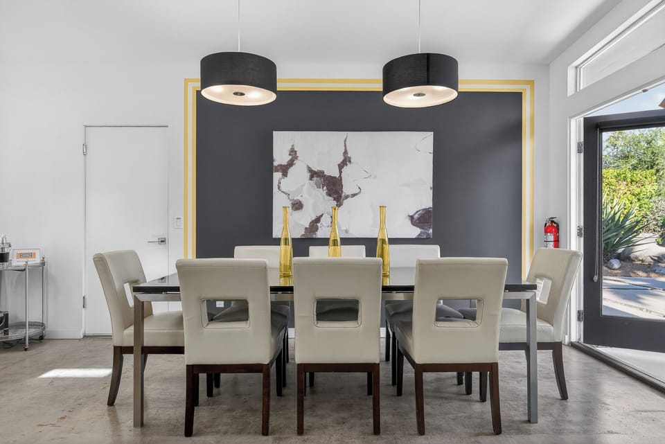 Gather around this sophisticated dining table for memorable meals, where modern art and elegant lighting create the perfect atmosphere for your group.