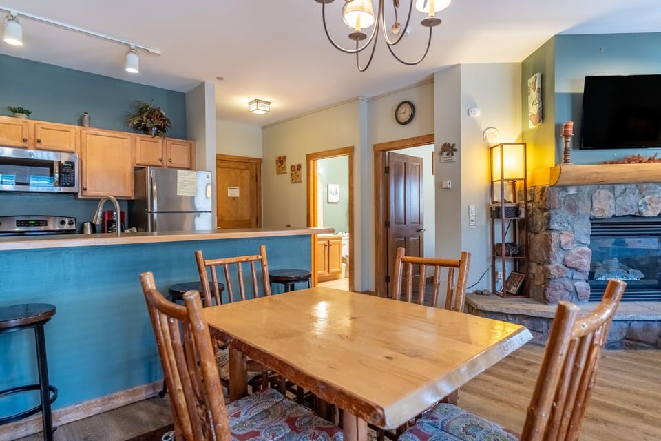 Your cozy dining space features warm wood furnishings and opens to a fully equipped kitchen, perfect for home-cooked meals together.