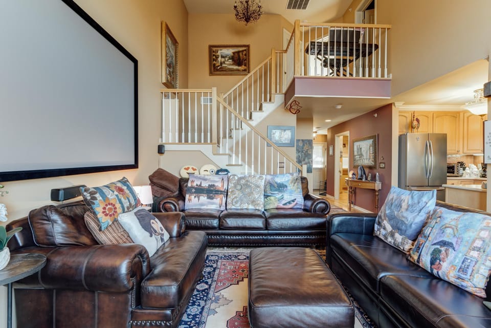 Spacious living room with cozy leather seating and vaulted ceilings