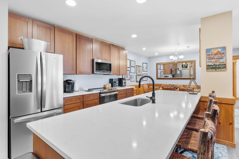 Your spacious kitchen awaits with gleaming countertops, modern appliances, and warm wood cabinetry perfect for preparing meals together.