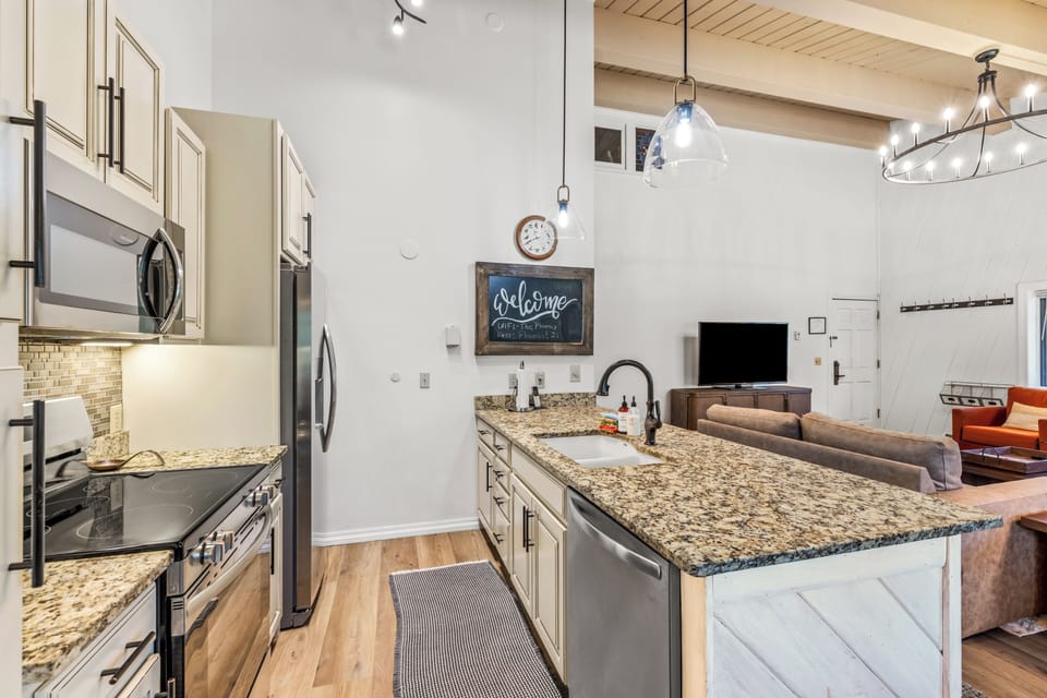 Your open-concept kitchen welcomes you with gleaming granite counters, stainless appliances, and warm lighting—perfect for preparing meals while staying connected to the living area.