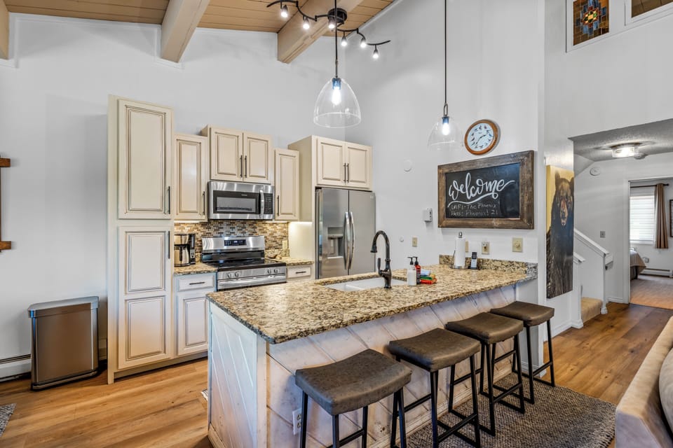 Step into your open kitchen with vaulted ceilings, granite counters, and modern appliances. Gather at the island for meals or conversation in this bright, welcoming space.