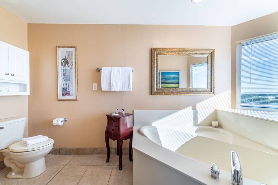 The Main Bathroom features a large soaking tub with ocean views & walk-in shower