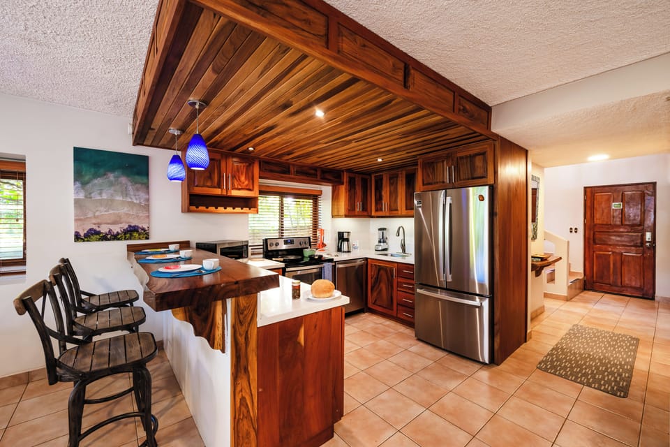 Modern kitchen in Playa Langosta, Tamarindo Costa Rica with quartz countertops, dining counter, and bright open design. This beachfront vacation rental blends stylish décor and spacious layout, ideal for family vacations and tropical living.