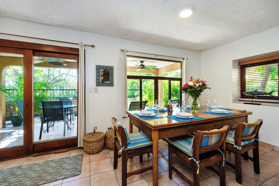 Dining area in Playa Langosta, Tamarindo Costa Rica vacation rental. Beautiful wood table with bright open space, and beachfront terrace visible through the window. Perfect for family meals, tropical living, and enjoying sunset dining by the ocean.