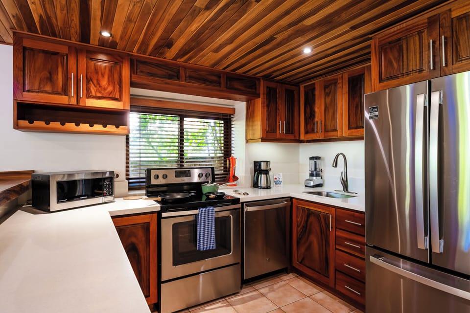 Modern kitchen close‑up in Playa Langosta, Tamarindo Costa Rica vacation rental. Quartz countertops, stainless steel appliances, and elegant décor highlight this beachfront villa, perfect for family vacations, cooking together, and tropical living.