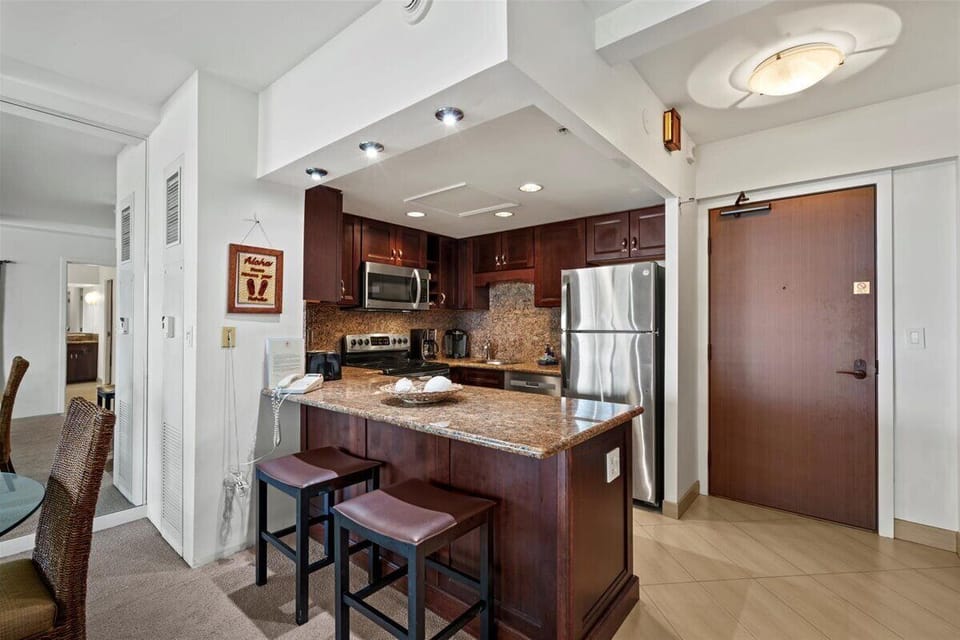 Your fully equipped kitchen features rich cabinetry, granite counters, stainless appliances, and a breakfast bar—perfect for enjoying meals or sipping morning coffee in comfort.