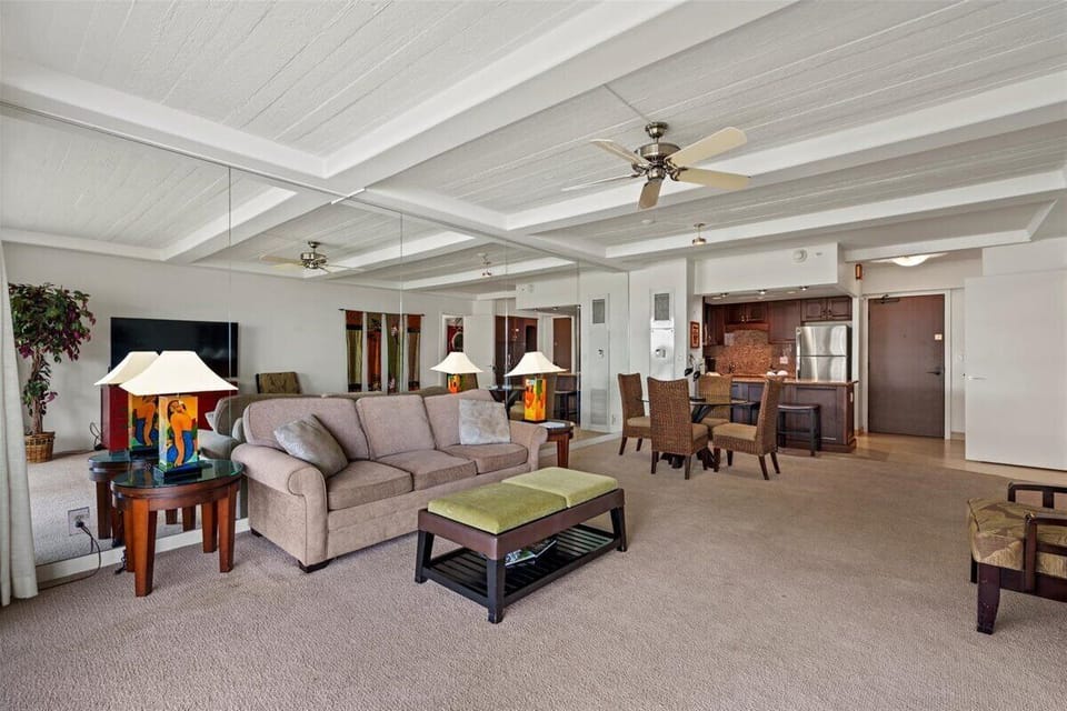 Step into your open-concept retreat where comfort meets island style. High beamed ceilings and ceiling fans keep you cool as you unwind on the plush sofa, gather around the dining table, or whip up a meal in your fully equipped kitchen.