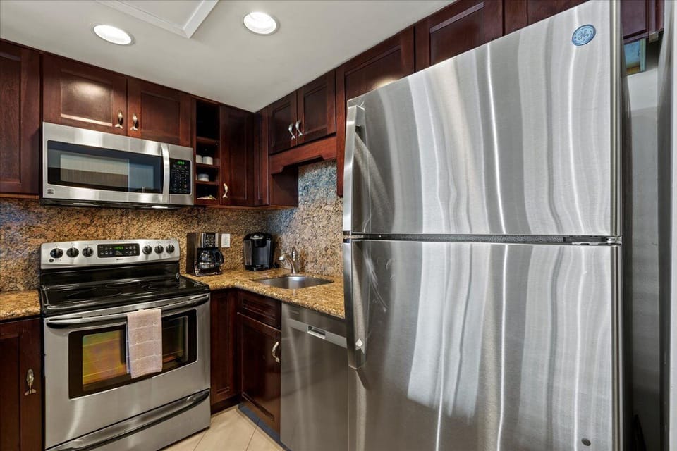 Your fully equipped kitchen features stainless steel appliances, granite countertops, and rich wood cabinetry—everything you need to prepare memorable meals during your stay.