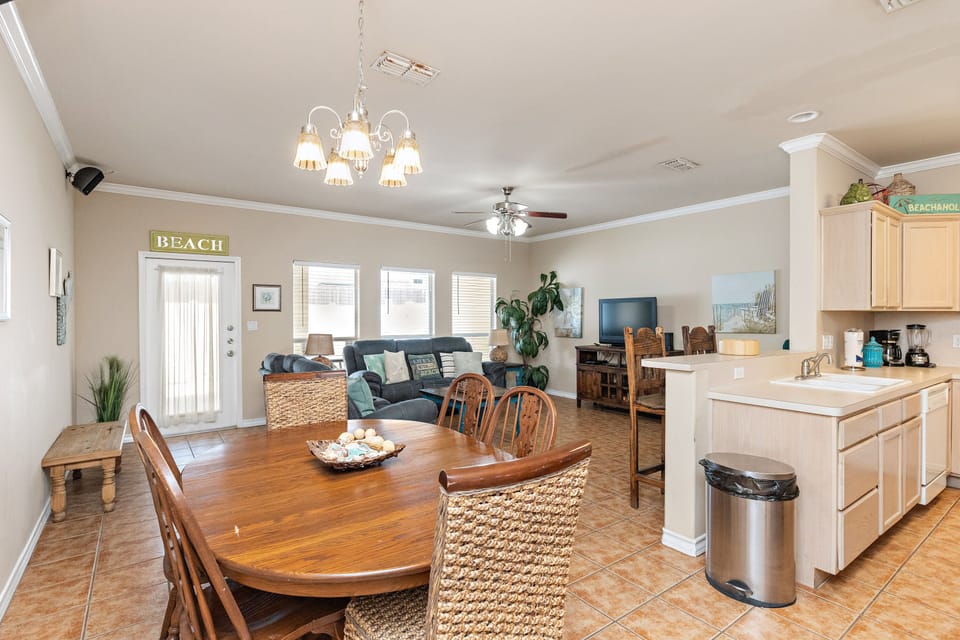 Gather around the inviting dining table while your chef prepares meals in the open kitchen, all with coastal charm throughout.