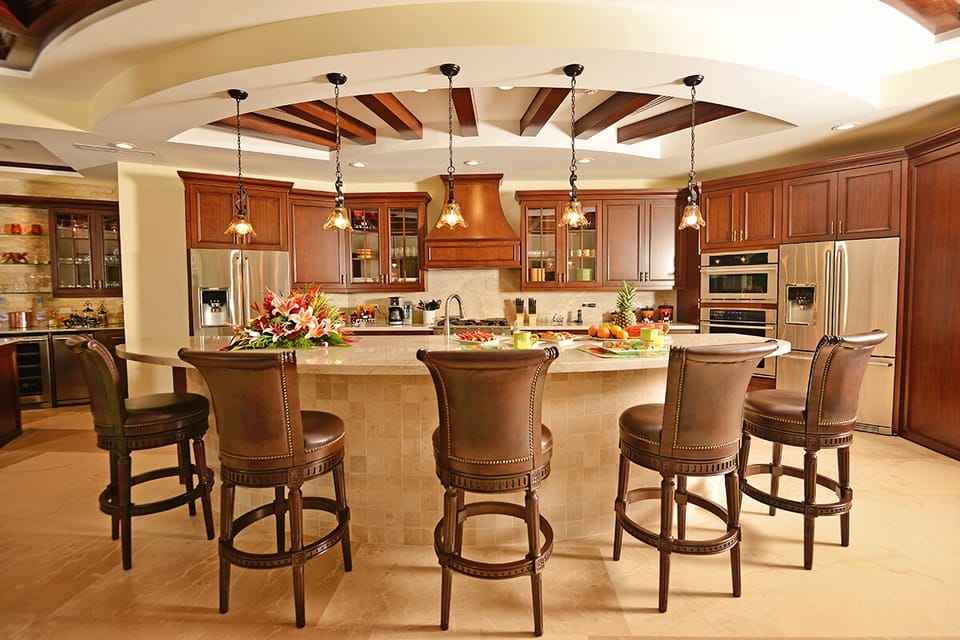 Gourmet Kitchen. Custom bar with glass cabinetry, glass shelves, icemaker, bar fridge, bar sink and cut stone backdrop.