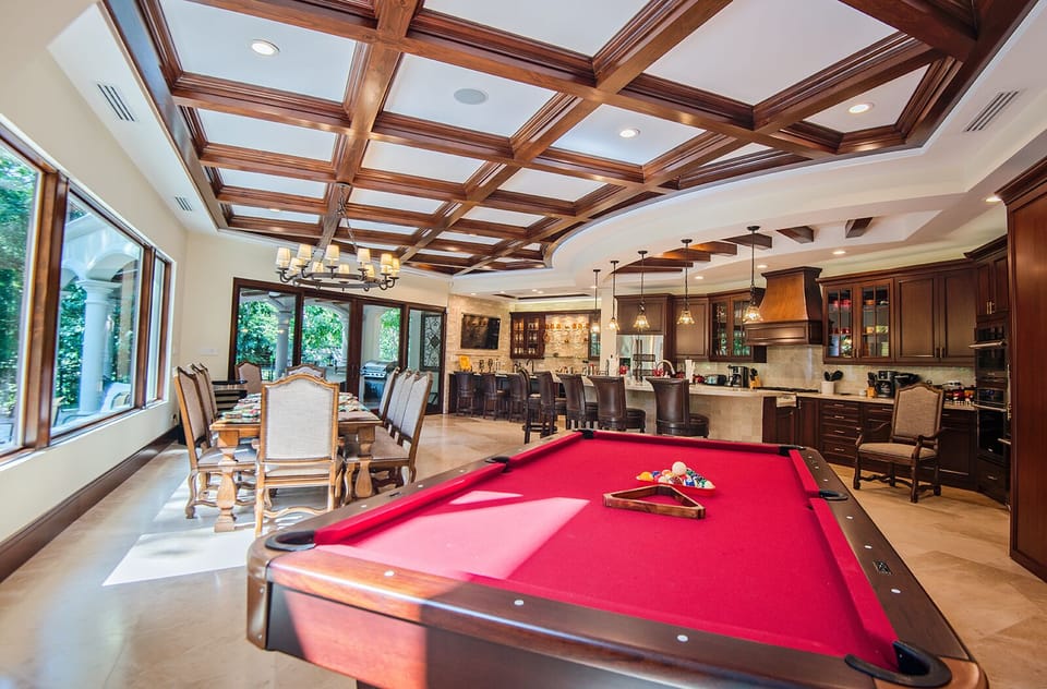 Open living room with pool table, dining area and gourmet kitchen.