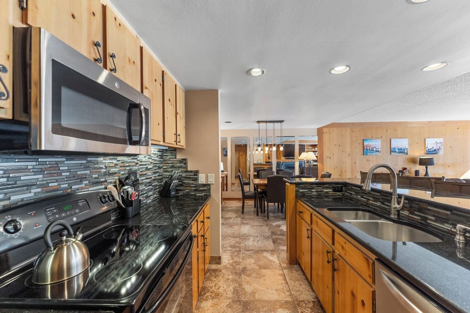 Your fully equipped kitchen awaits with granite counters, stainless appliances, and elegant tile backsplash for memorable meal prep.