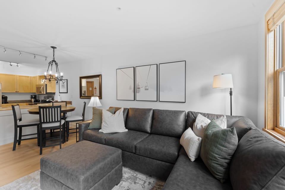 Relax on your plush sectional sofa while natural light streams through large windows into this open-concept living space.
