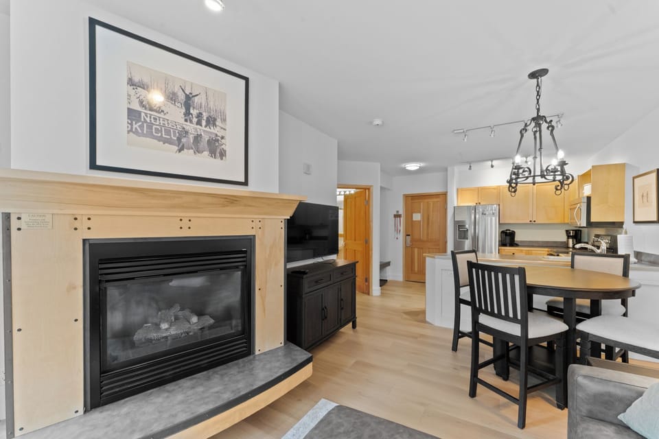Your cozy open-concept space combines a warm fireplace, modern kitchen, and intimate dining nook for perfect mountain evenings.