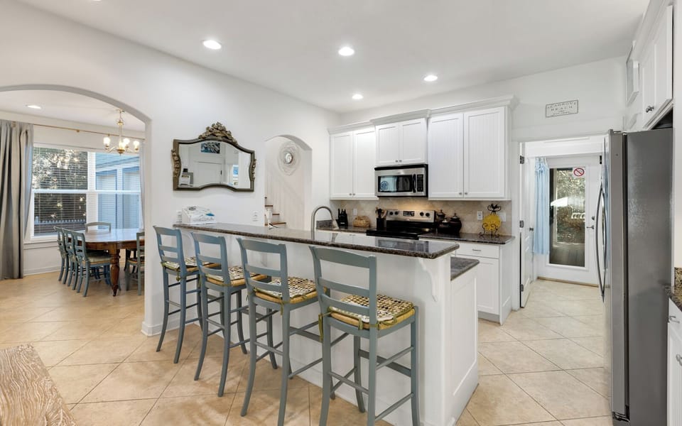 You'll love gathering around this spacious kitchen island while preparing meals together, with its elegant granite countertops and charming breakfast bar seating.