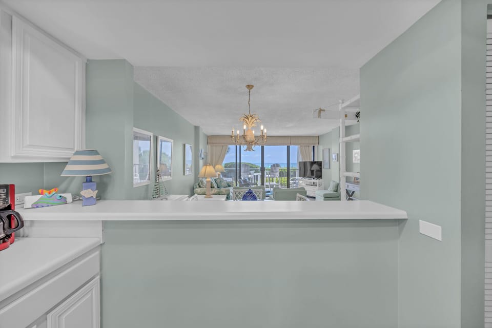 Prepare your favorite meals in this bright kitchen with easy flow into the airy living area, where soft coastal tones and ocean views create your perfect beach getaway.