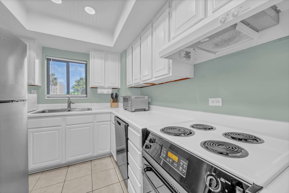 This bright, fully-equipped kitchen offers everything you need for easy meal prep, with crisp white cabinetry, ample counter space, and modern appliances at your fingertips.