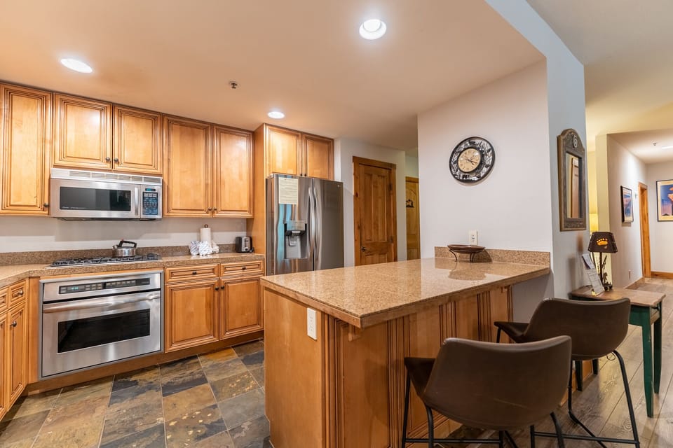 Your fully equipped kitchen features granite countertops, stainless steel appliances, and a breakfast bar where you can savor your morning coffee.