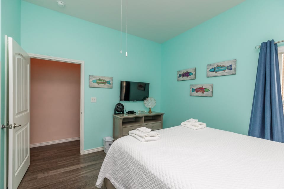 Drift off in your serene aqua retreat, where coastal-themed art and crisp linens create the perfect seaside sanctuary.