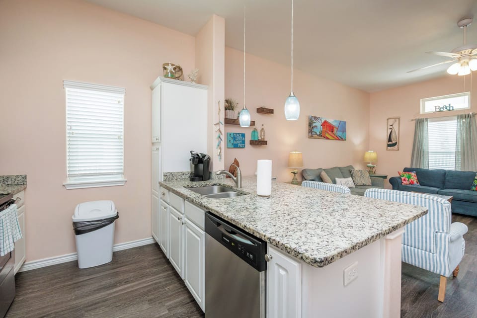 Your spacious kitchen island becomes the heart of your stay, perfect for preparing meals while chatting with loved ones in the cozy living area.