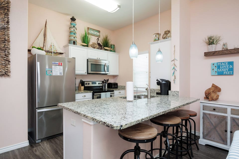 Whip up your favorite meals in this charming coastal kitchen with granite counters, modern appliances, and beach-themed touches.