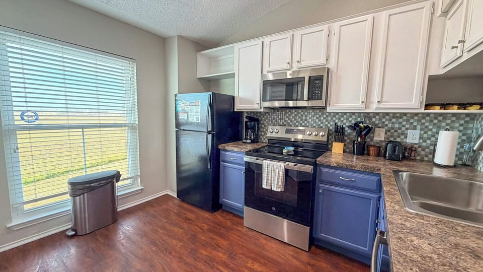 Cook your favorite meals in this fully-equipped kitchen featuring granite countertops, stainless steel appliances, and all the tools you need for a perfect stay.