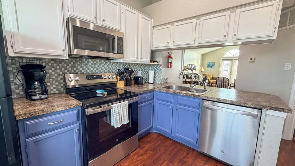 Cook memorable meals in your fully-equipped kitchen with granite counters, stainless appliances, and charming blue cabinets.