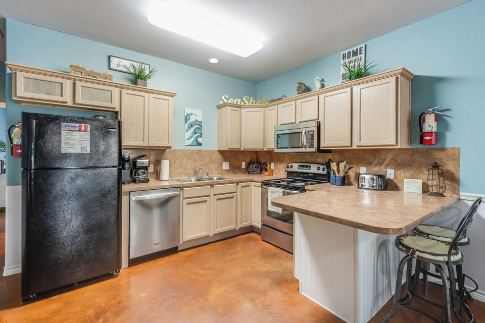 Your fully equipped kitchen features modern appliances, granite countertops, and a breakfast bar where you can enjoy morning coffee.