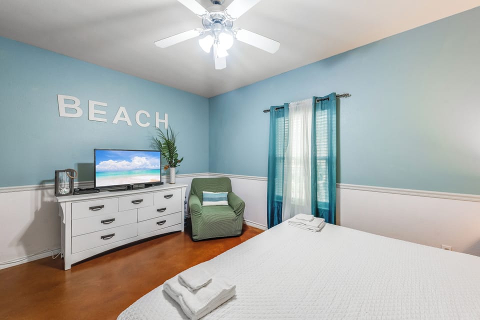 Drift off in your beach-themed bedroom with soothing ocean hues, comfy seating, and fresh towels awaiting your arrival.