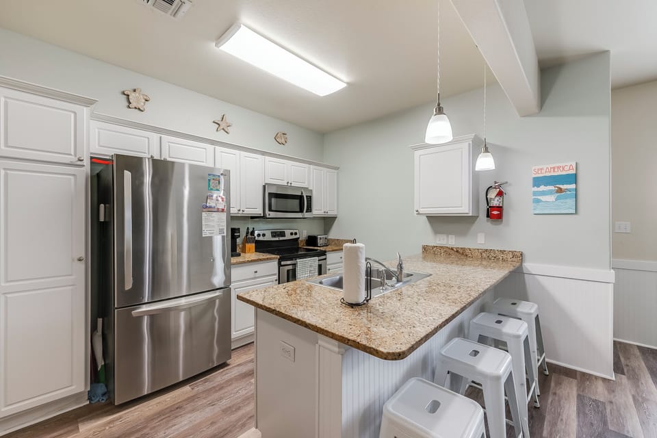 Your fully equipped kitchen features granite counters, stainless appliances, and a breakfast bar where you can start each morning with coffee.