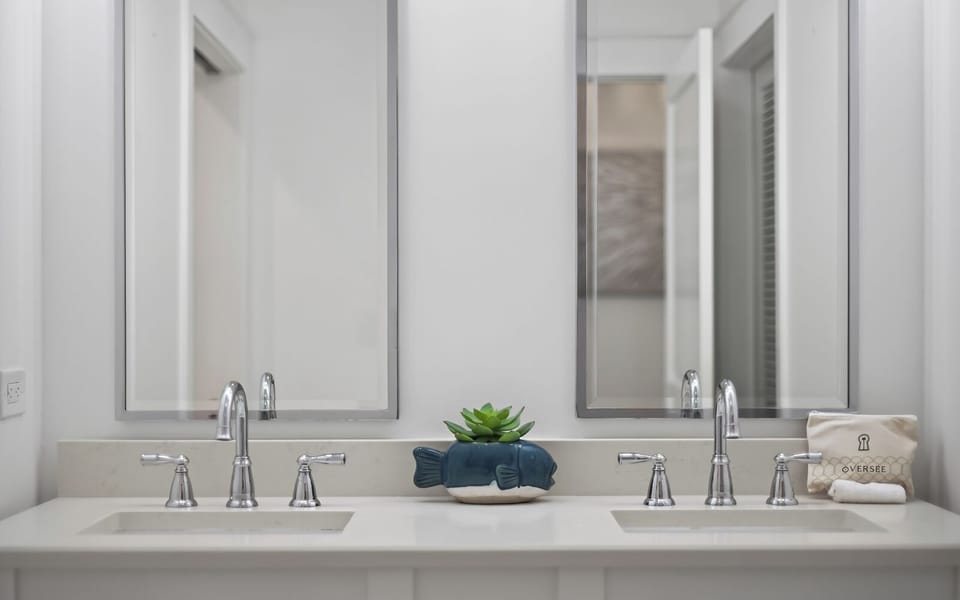 You'll love this elegant dual-sink vanity with soft lighting and thoughtful touches like fresh greenery to start your mornings right.