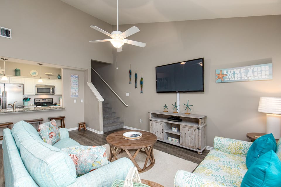 Unwind in your bright living room with coastal touches, comfy seating, and entertainment center for relaxing evenings.