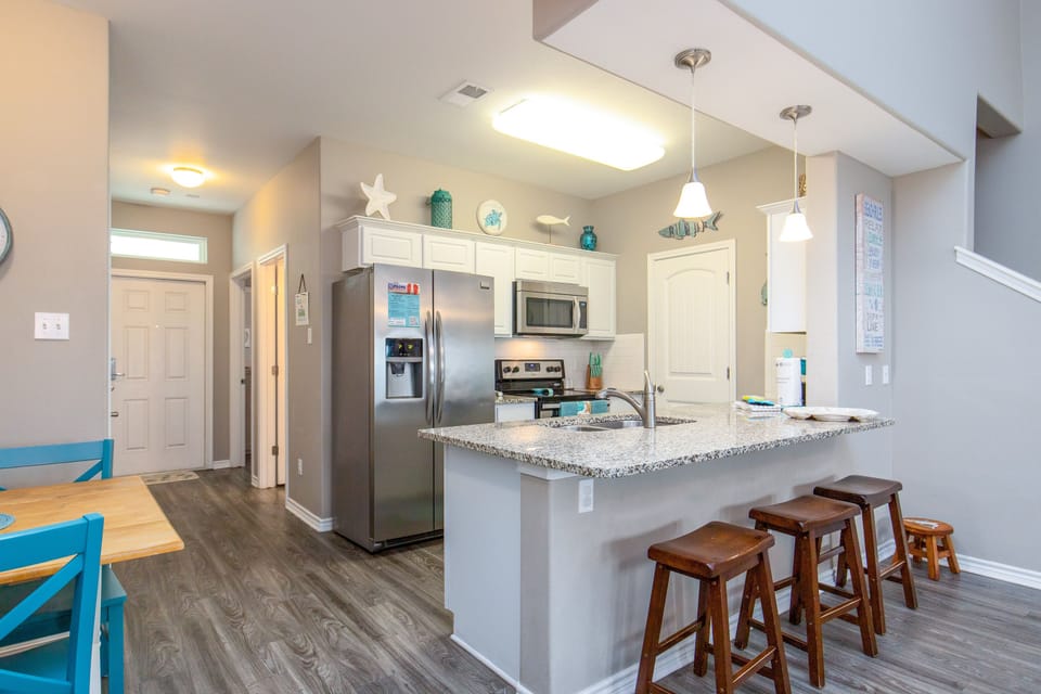 Your open kitchen invites relaxed mornings with granite counters, stainless appliances, and a breakfast bar perfect for coffee and conversation.