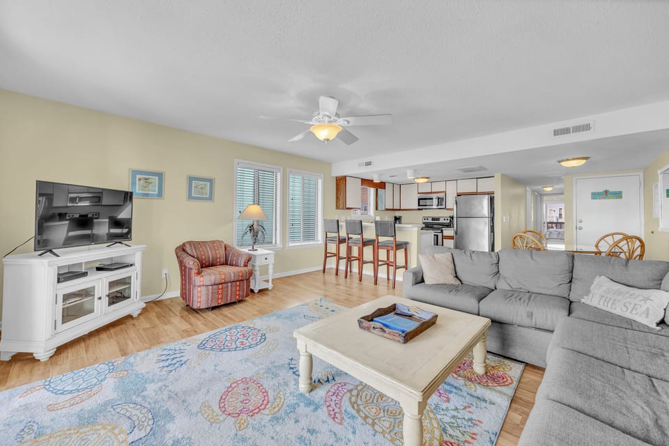 Your open-plan living space blends coastal charm with comfort—sink into the plush sectional, gather at the breakfast bar, and enjoy all the conveniences of a fully equipped kitchen.