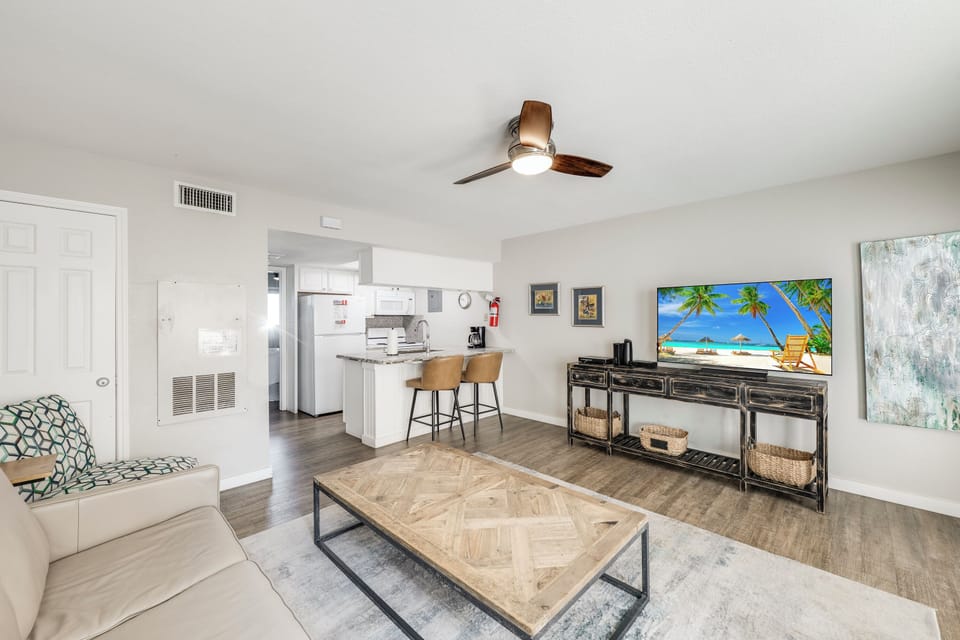 Unwind in your bright, open living space with a large smart TV, comfortable seating, and a convenient breakfast bar—perfect for relaxing after your beach adventures.