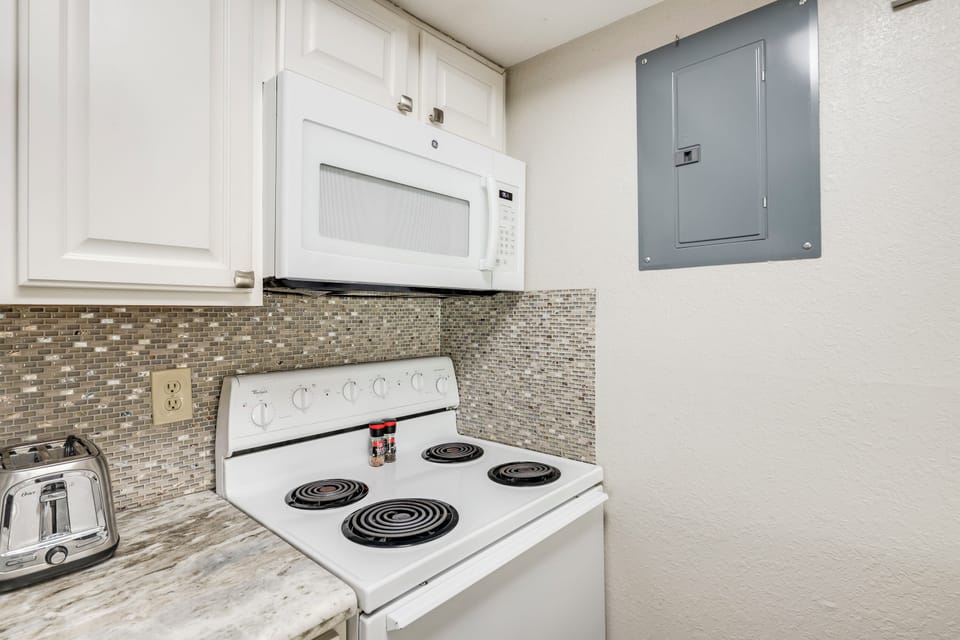 Your fully equipped kitchen features modern appliances and stylish tile backsplash, making meal prep easy and enjoyable during your stay.