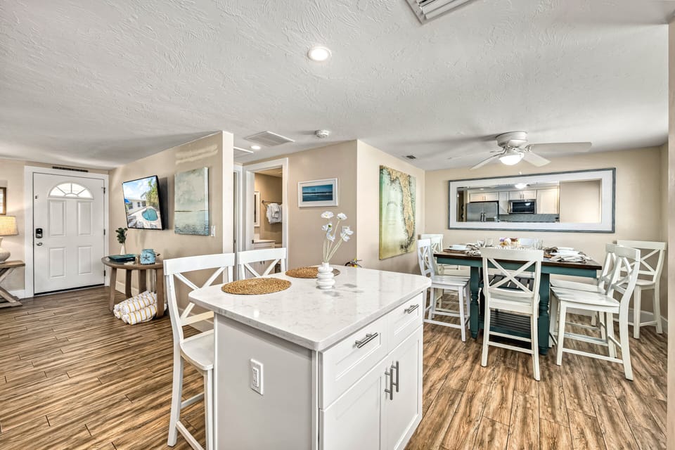 Gather around the kitchen island where cooking and conversation flow effortlessly, framed by a dining area.