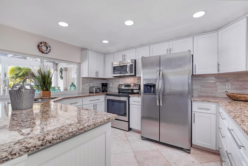 The sleek kitchen boasts stainless steel appliances, granite countertops, and everything you need to cook.