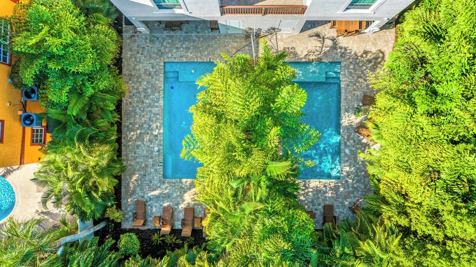 Your private oasis begins here—two sparkling rectangular pools each with a Baja tanning shelf and a soothing fountain at its heart.