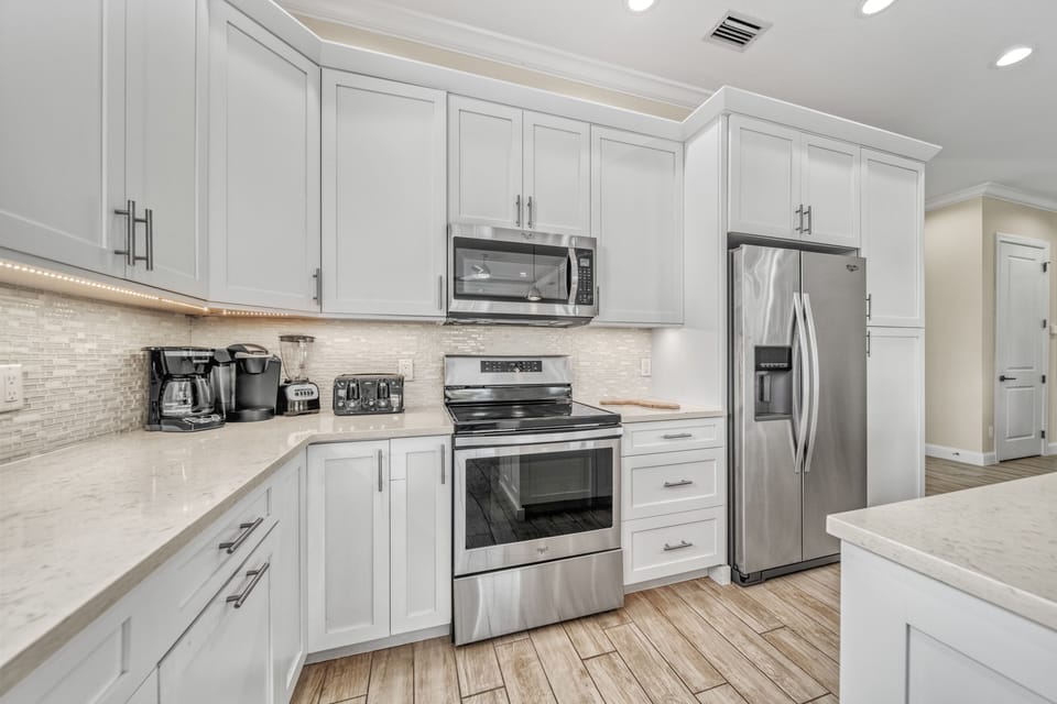 Fully equipped gourmet kitchen with quartz countertops and stainless appliances—prep meals with ease while enjoying the open layout.