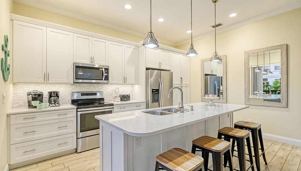 Bright, breezy, and fully stocked—this chef's kitchen with island and breakfast bar is the heart of every delicious day.