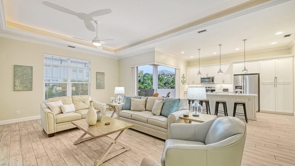 An expansive perspective revealing the open-concept flow between the living room and fully equipped kitchen, creating a seamless space for socializing.