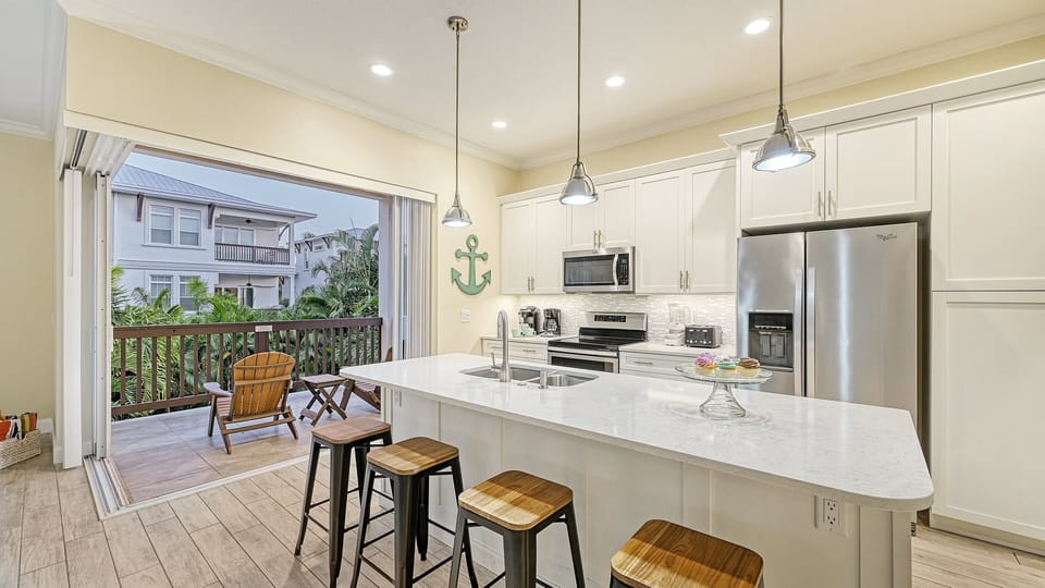 A spacious kitchen featuring a large island and breakfast bar, perfect for preparing meals or casual dining.