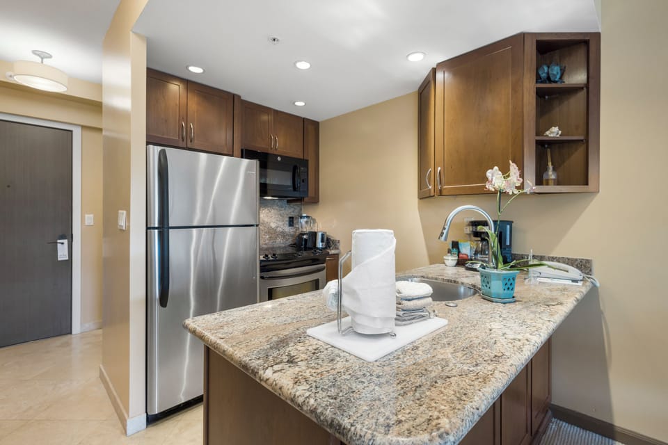 Your fully equipped kitchen features granite countertops, stainless steel appliances, and rich wood cabinetry—perfect for preparing meals at your own pace during your stay.